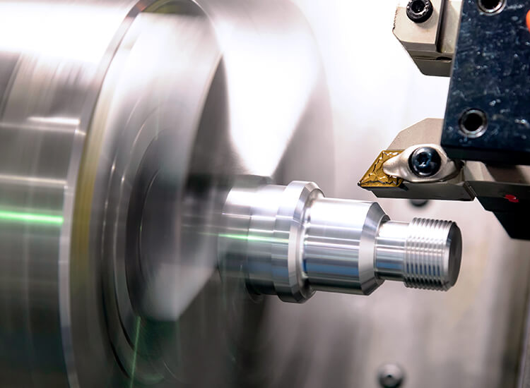 Drehmaschine im Betrieb. Links das Werkstück und Rechts Diamantspitze.