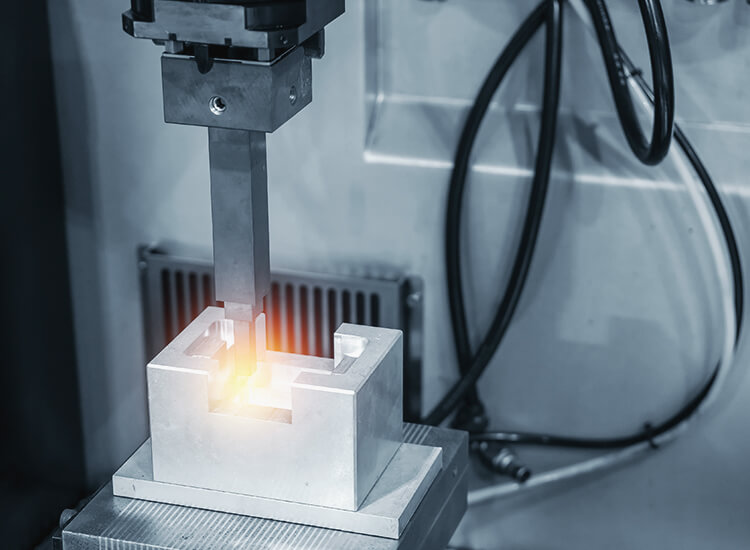 Erodiermaschine bearbeitet ein Werkstück, wodurch ein Lichtbogen entsteht.
